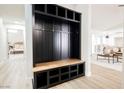 Hallway featuring a dark-stained built-in mudroom storage bench with wood accents and access to living area at 8757 Beluga Way, Las Vegas, NV 89117