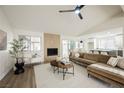 Inviting living room featuring a fireplace, vaulted ceilings, neutral decor, and access to the backyard at 8757 Beluga Way, Las Vegas, NV 89117