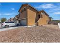 Side view of a two-story home with a two-car garage and low-maintenance desert landscaping at 9541 Vast Valley Ave, Las Vegas, NV 89148