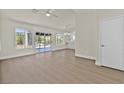 Open-concept living room with laminate floors, sliding glass doors, and an adjacent kitchen at 9552 Gold Bank Dr, Las Vegas, NV 89134