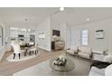 Bright, open-concept living space with modern furnishings, a dining area, and an adjacent kitchen at 9552 Gold Bank Dr, Las Vegas, NV 89134