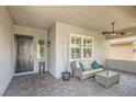 Inviting covered front porch with stylish seating, ceiling fan, and brick-paved flooring at , Henderson, NV 89011