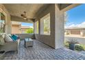 Inviting covered front porch with stylish seating, ceiling fans, and brick-paved flooring at , Henderson, NV 89011