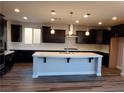 Modern kitchen featuring dark cabinets, an island with a white countertop, and stainless steel appliances at 1027 Cambridge Park St, Las Vegas, NV 89148