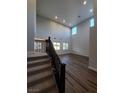 Bright living room with high ceilings, wood-look floors, and staircase with dark wood railings at 1027 Cambridge Park St, Las Vegas, NV 89148