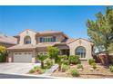 Inviting two-story home featuring a tile roof, a two-car garage, and desert landscaping at 11112 Pine Greens Ct, Las Vegas, NV 89144
