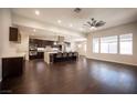 Spacious living room open to modern kitchen featuring dark hardwood floors and lots of natural light at 11119 River Hills Ln, Las Vegas, NV 89135