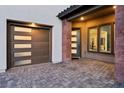 Close up of modern two-car garage and front door with brick and stone accents on a brick driveway at 12155 Sage Thunder Ave, Las Vegas, NV 89138
