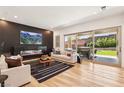 Open-concept living area with a fireplace, sliding glass doors to the patio, and hardwood floors at 12155 Sage Thunder Ave, Las Vegas, NV 89138