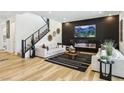 Bright and stylish living room featuring hardwood floors, a modern fireplace, and staircase to the second floor at 12155 Sage Thunder Ave, Las Vegas, NV 89138