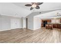 View of a living room with wood flooring, ceiling fan, and open access to the kitchen at 1536 Leatherleaf Dr, Las Vegas, NV 89123