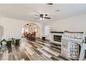 Bright living room featuring wood-look floors, a fireplace, and an archway to the dining area at 1538 Pony Ranch Cir, Henderson, NV 89014