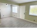 Open living room with two windows, overhead ceiling fan, and light gray wood-look floors at 212 Orland St # 22, Las Vegas, NV 89107