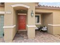 Inviting porch with stylish seating and a vibrant red door, creating a warm welcome at 2213 Chandler Ranch Pl, Laughlin, NV 89029