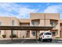 Beige condo building featuring covered parking, landscaped grounds, and clear blue sky at 2232 Aspen Mirror Way # 202, Laughlin, NV 89029