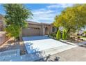 Inviting single-story home featuring a spacious driveway and desert-style landscaping at 2673 Paris Amour St, Henderson, NV 89044