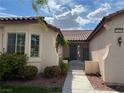 Inviting home entrance with a tiled roof, landscaped garden, and secure gate, offering curb appeal at 2855 Grande Valley Dr, Las Vegas, NV 89135