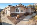 Single-story home featuring a low-maintenance landscape with rock, desert shrubs and a sidewalk at 3342 Pheasant Canyon Way # 1013, Laughlin, NV 89029