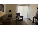 Cozy living room featuring an olive sofa, brown recliner and natural light from sliding glass door at 3550 Bay Sands Dr # 3051, Laughlin, NV 89029