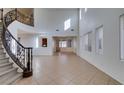 Spacious living room with soaring ceilings, elegant staircase, and natural light at 3774 Dusky Flycatcher St, Las Vegas, NV 89122