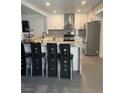 Modern kitchen with white cabinets, stainless steel appliances, granite countertops, and eat-in breakfast bar at 3831 Atlantis St, Las Vegas, NV 89121