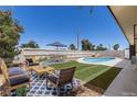 Landscaped backyard with pool, dining area, outdoor seating, and privacy fence at 4450 San Rafael Ave, Las Vegas, NV 89120