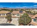 Aerial view of a two-story house with solar panels in a suburban neighborhood with mountain views at 4804 Laurentia Ave, Las Vegas, NV 89141