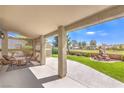 Covered patio with comfortable seating area overlooking a well-maintained backyard at 5000 Linkside Dr, Las Vegas, NV 89130