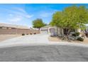 Charming single-story home featuring a three-car garage and a well-maintained front yard with mature trees at 6032 Red Glitter St, North Las Vegas, NV 89031