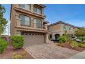 Elegant stucco home featuring a brick driveway and a covered porch at 6056 Atlantis Dream Ave, Las Vegas, NV 89139