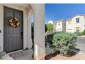 Inviting front entrance with a decorative wreath on the gray front door and an arched entryway at 6271 Sunset Spring Ave, Las Vegas, NV 89122