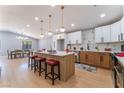 Open-concept kitchen with island seating, stainless appliances, white and wood cabinets, and adjacent dining area at 6324 Eugene Ave, Las Vegas, NV 89108