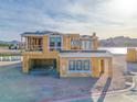 A modern home's framing showcases lake views and architectural elements at 65 Bellissima Lago Ct, Henderson, NV 89011