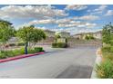 Gated community entrance with lush landscaping and well-maintained street at 7052 Blissful Peak St, North Las Vegas, NV 89084
