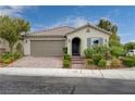 Charming single-story home featuring a two-car garage, tile roof, and beautifully landscaped front yard at 7052 Blissful Peak St, North Las Vegas, NV 89084