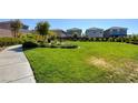 Lush green community lawn with walking path, bench, trees, and well-manicured landscaping at 7052 Blissful Peak St, North Las Vegas, NV 89084