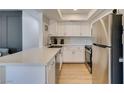 Modern kitchen featuring stainless steel appliances, white cabinets, and sleek countertops at 718 Nectarine Ct, Henderson, NV 89014