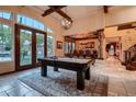 Bright game room with pool table, natural light, and views of the backyard, offering a stylish recreational space at 7501 Midnight Rambler St, Las Vegas, NV 89149