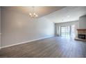 Bright living room with hardwood floors, neutral paint, a fireplace, and sliding glass door leading to the backyard at 7911 Canoe Ln, Las Vegas, NV 89145