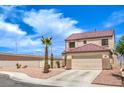 Charming two-story home featuring desert landscaping, a palm tree, and a two-car garage at 7964 Lovely Pine Pl, Las Vegas, NV 89143