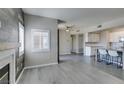 An open concept living area showcases wood-look floors, an attractive fireplace, and a view of the kitchen at 8250 N Grand Canyon Dr # 2001, Las Vegas, NV 89166