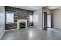 Inviting living area featuring wood-look floors, a fireplace, plantation shutters, and sliding doors at 8250 N Grand Canyon Dr # 2001, Las Vegas, NV 89166