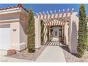 Inviting home entrance framed by mature trees and a covered walkway at 8300 Slate Harbor Cir, Las Vegas, NV 89128