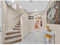 Bright hallway featuring tile flooring, staircase, and decorative console table with flower arrangement at 8335 Martinborough Ave, Las Vegas, NV 89131
