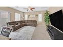 Comfortable living room with plush sectional sofa, ceiling fan, and sliding glass door at 8335 Martinborough Ave, Las Vegas, NV 89131