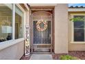 A decorative metal security door with a wreath and welcome sign enhances the home's curb appeal at 8608 Willow Cabin St, Las Vegas, NV 89131