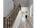 Entry hallway featuring wood-look floors, staircase with wood railing, and an abundance of natural light at 8873 Howell St, Las Vegas, NV 89166