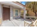 Inviting covered front porch with a decorative railing and a secure front door at 9174 Mcginnis Ave, Las Vegas, NV 89148
