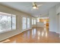 Open-concept living room with hardwood floors, a ceiling fan, and natural light from the windows and glass doors at 10009 Netherton Dr, Las Vegas, NV 89134
