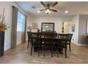 Spacious dining room featuring a dark wood table, wood flooring, and a modern ceiling fan at 1018 Snow Bunting Ct, Henderson, NV 89002